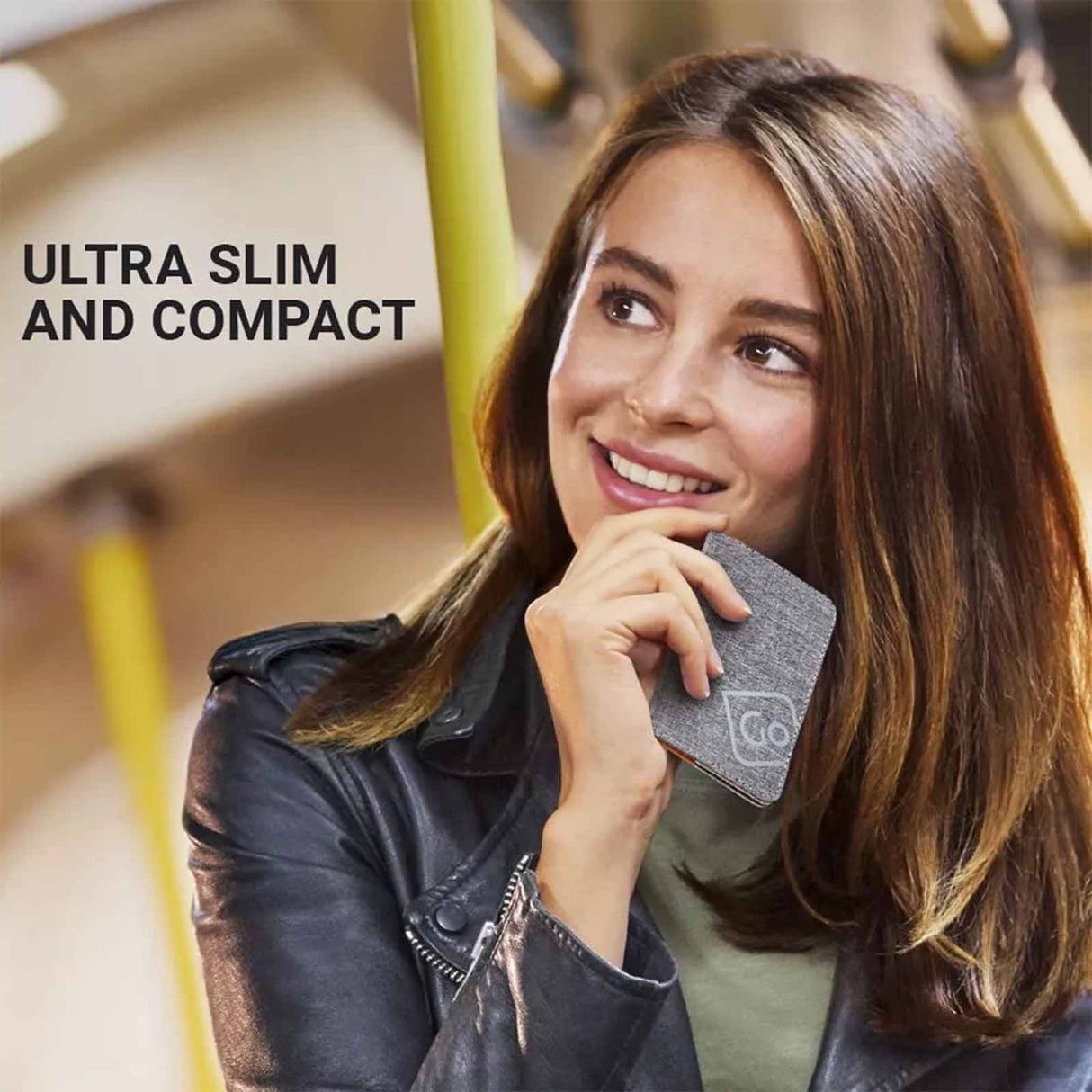 Woman holding an RFID card holder with text 'Ultra Slim and Compact' on a blurred background