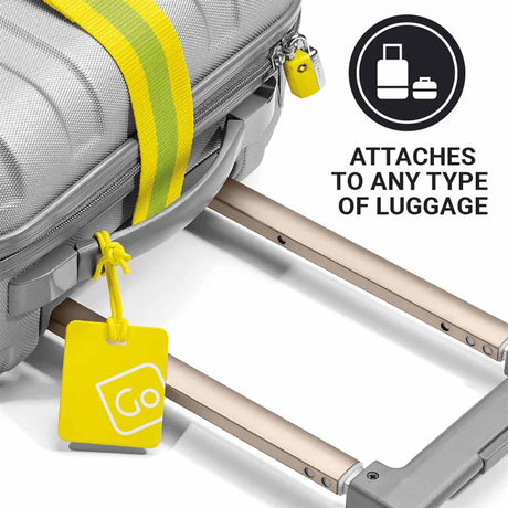 Yellow luggage tag attached to a suitcase with a rolling suitcase in the background.