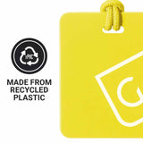 Yellow luggage tag with a recycling symbol and text indicating recycled plastic on a white background