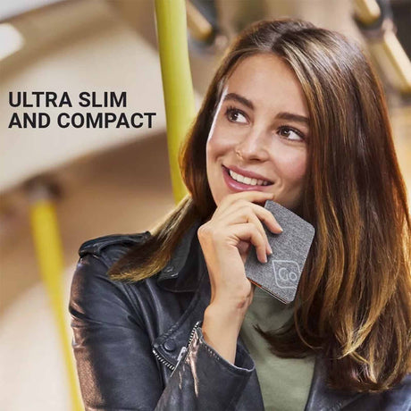 Woman holding an RFID card holder with text 'Ultra Slim and Compact' on a blurred background