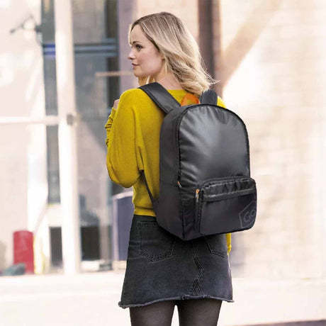 Woman wearing a black backpack in an urban setting