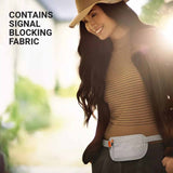 Woman wearing a brown top with text about signal blocking fabric, outdoors.