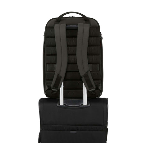 Dark Green backpack shown from the back, resting on top of a black rolling suitcase against a plain white background.