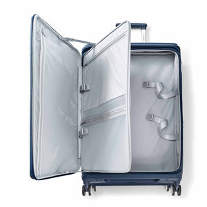A navy blue hard-shell suitcase shown open from an overhead angle, revealing a light gray interior organizer with zippered compartments and a carry-on strap, set against a plain white background.