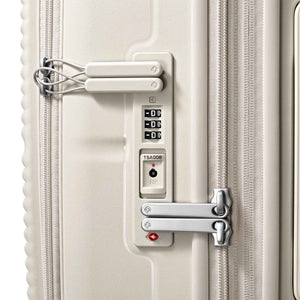 Close-up of a hard-shell suitcase lock area showing a TSA-approved combination lock, a small padlock, and a silver latch on a light beige/cream suitcase.
