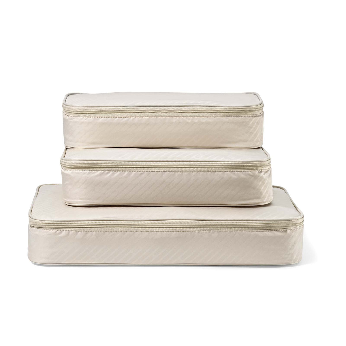 Set of three beige quilted storage cubes on a white background