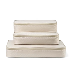 Set of three beige quilted storage cubes on a white background