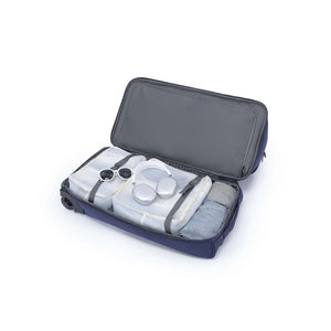 An open navy blue camera gear bag with gray interior lining, shown on a white background. Inside are several translucent plastic storage containers and straps, with a small camera accessory visible on the left side.