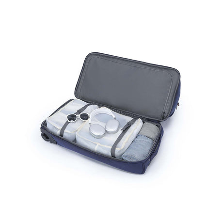 An open navy blue camera gear bag with gray interior lining, shown on a white background. Inside are several translucent plastic storage containers and straps, with a small camera accessory visible on the left side.