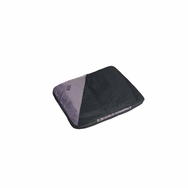 A small black compression cube for packing or organizing, with a visible brand tag.